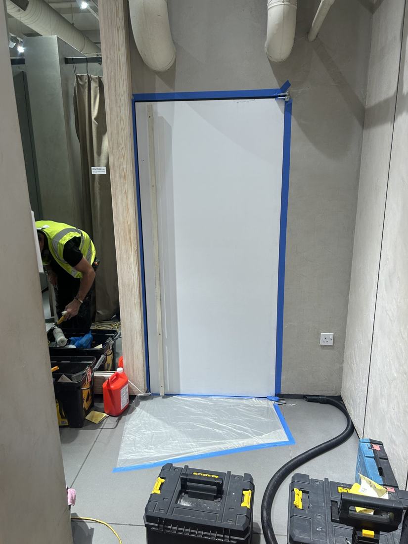 Drywall wall masked and prepared for painting in a retail unit