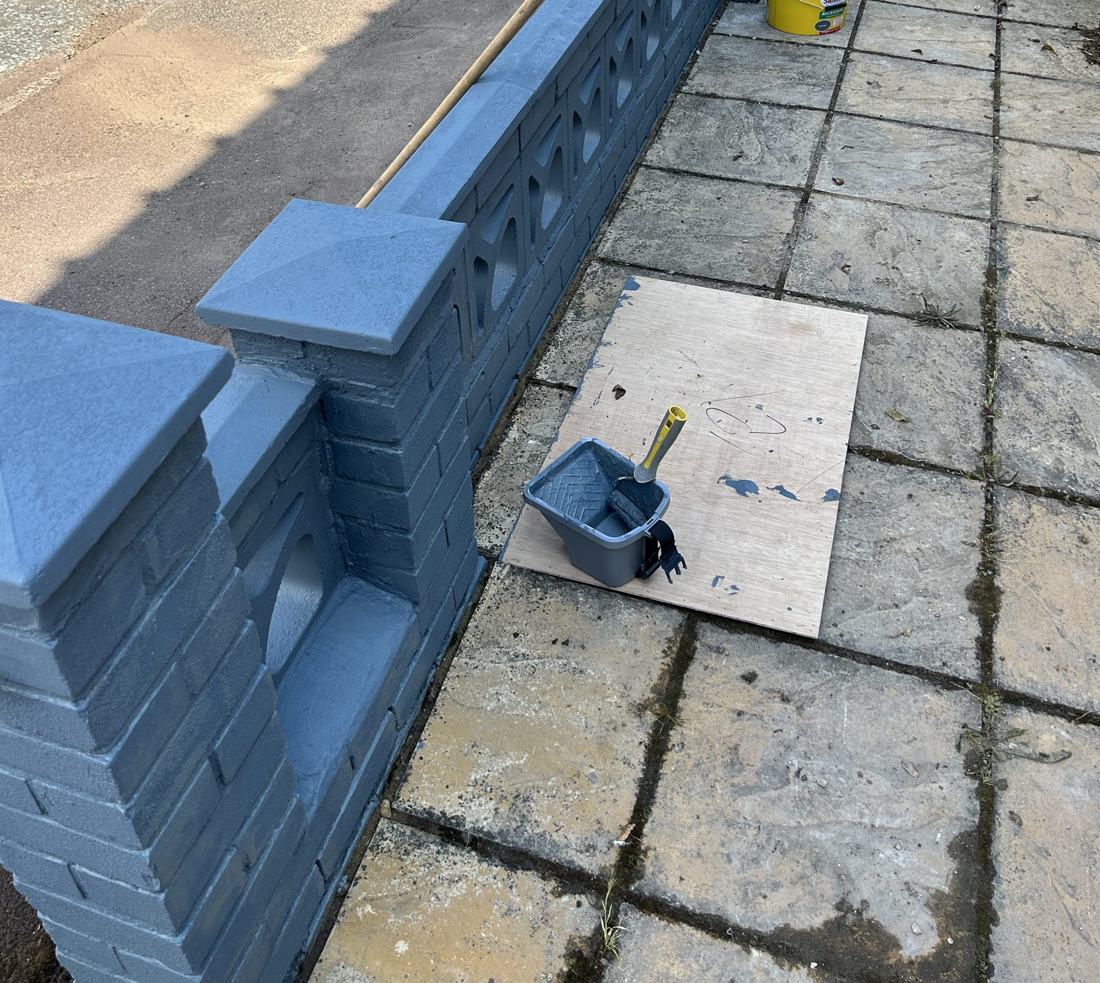 Muro del jardín delantero repintado en azul grisáceo