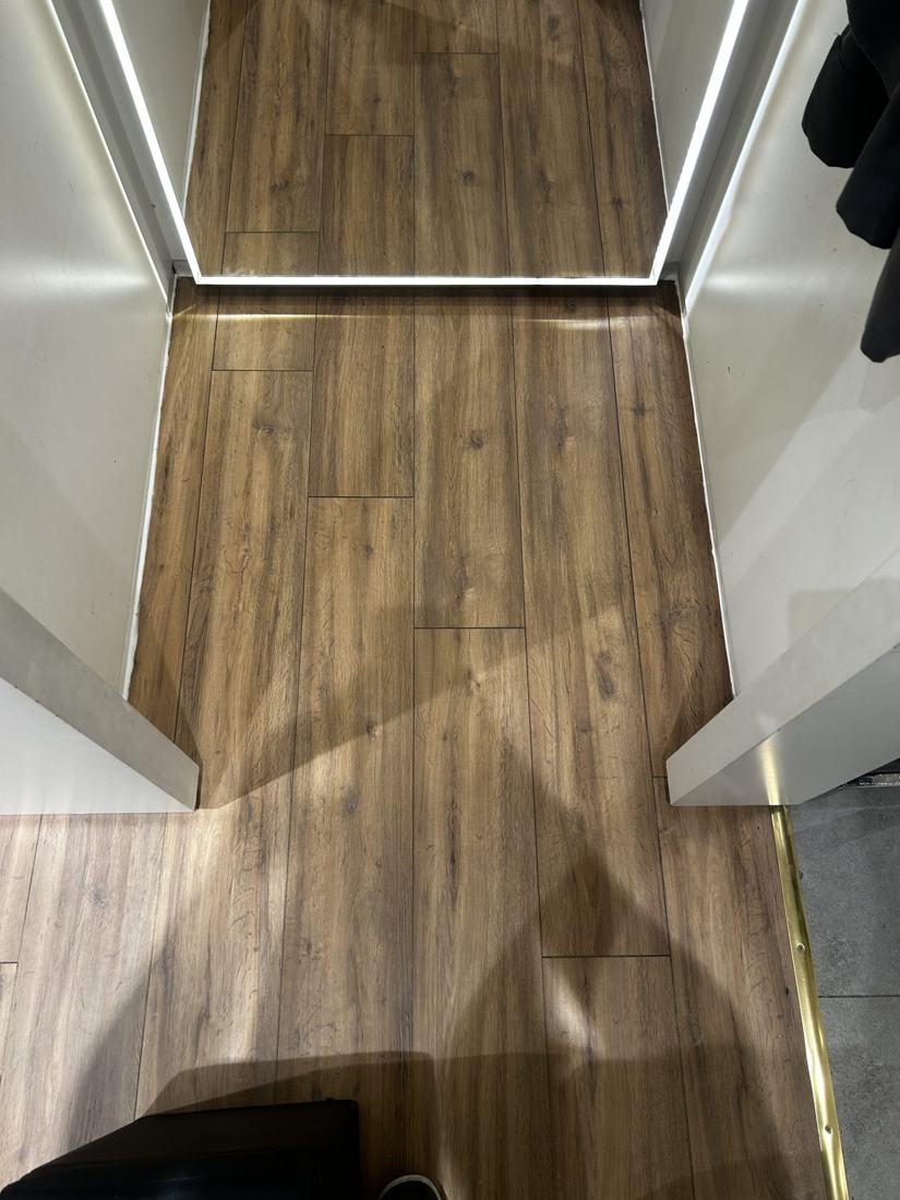 Finished wood-effect laminate flooring with LED-lit threshold