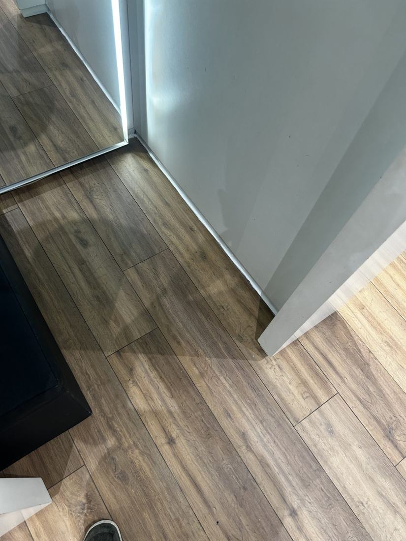Close view of laminate planks meeting a wall