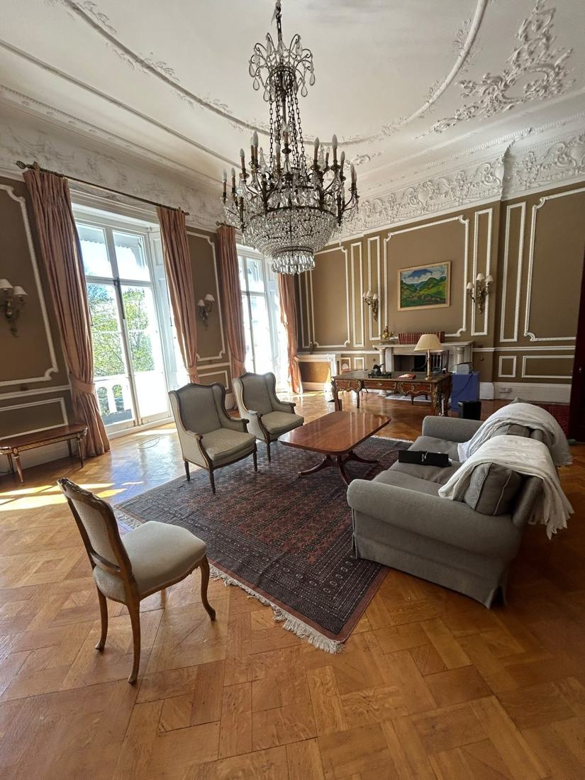 Salón clásico recién decorado con techo ornamental y parqué
