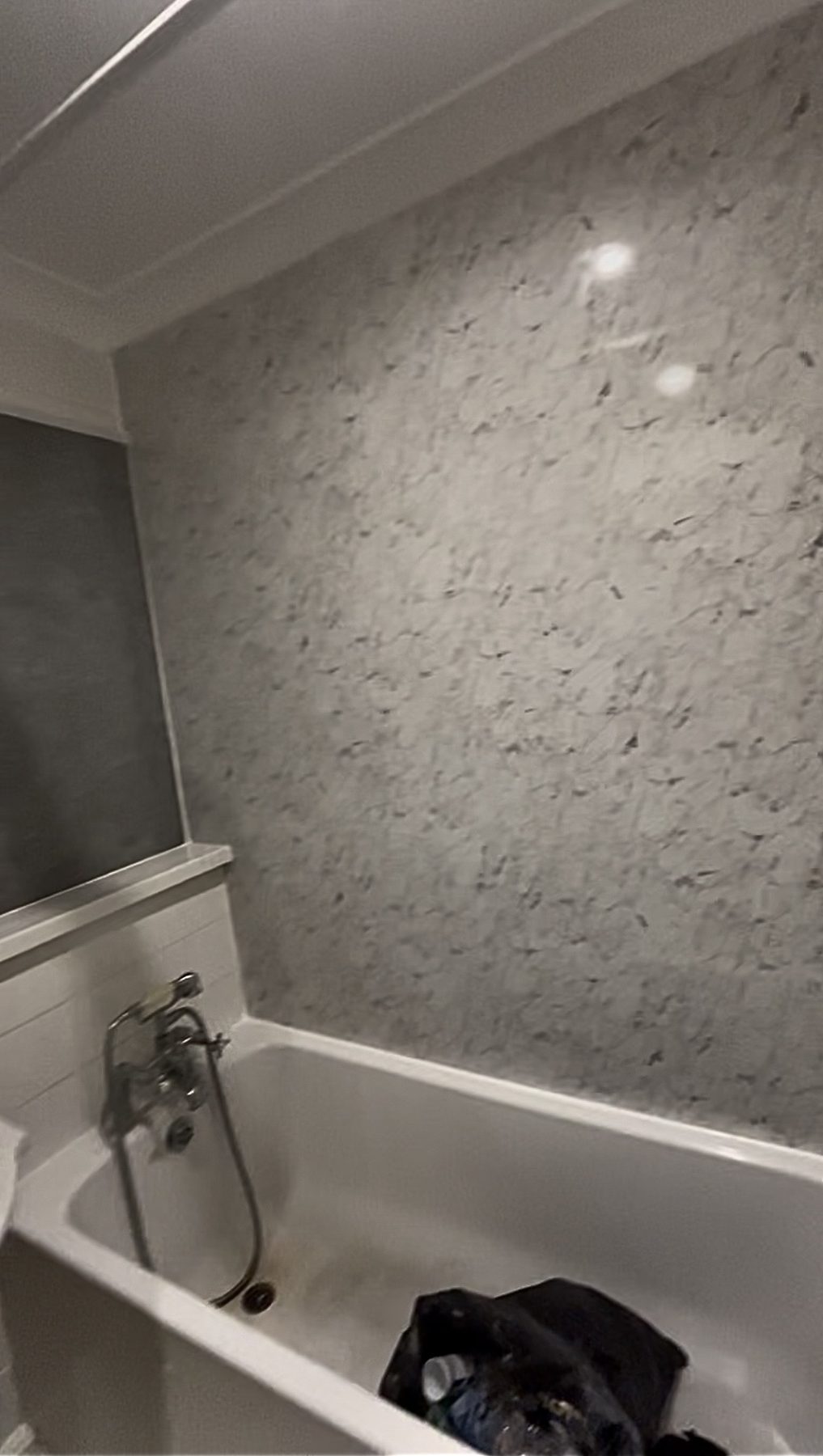 Bathroom wall renovated with a new wall finish behind the bath